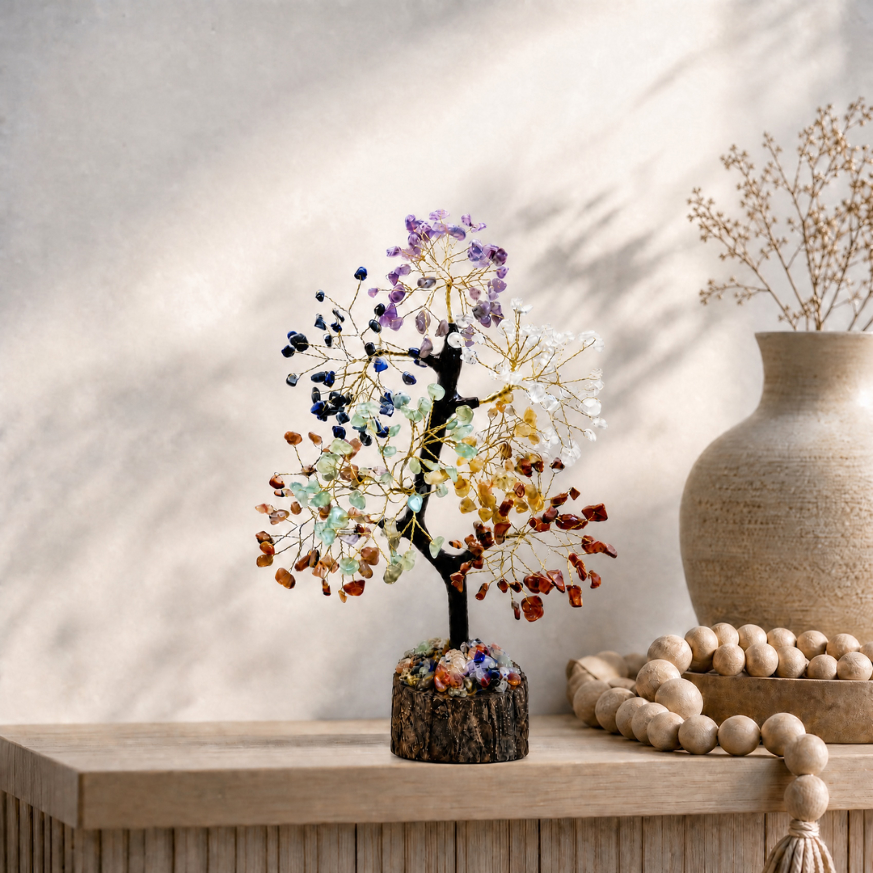 Chakra crystal tree on an entryway console with a vase and wooden beads